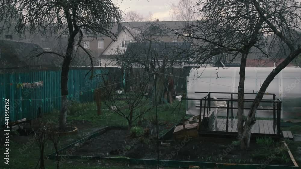 It rains with hail on the street during the day in the garden It rains with hail on the street during the day in the garden