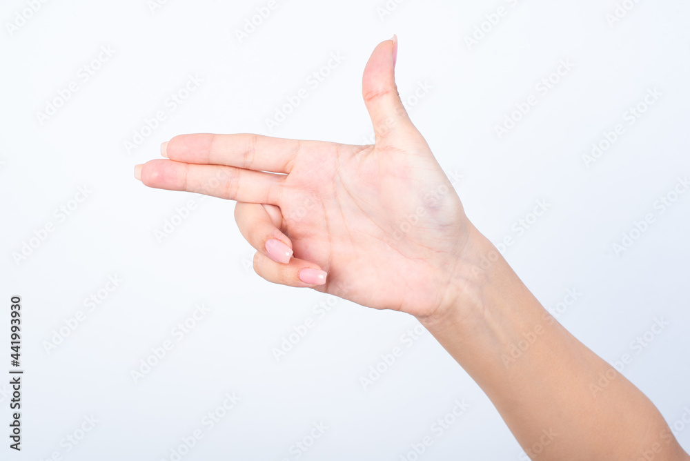 Woman's hand with pink manicure over isolated white background pointing aside or making gunfire gesture Woman's hand with pink manicure over isolated white background pointing aside or making gunfire gesture