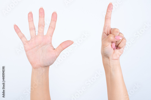 hands with pink manicure over white background pointing up with fingers number six. 