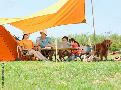 Happy family of four and dog camping out