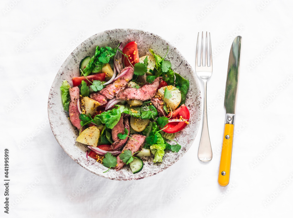 Potato, beef steak, fresh greens and vegetable salad on a light background, top view. Balanced diets healthy food Potato, beef steak, fresh greens and vegetable salad on a light background, top view. Balanced diets healthy food