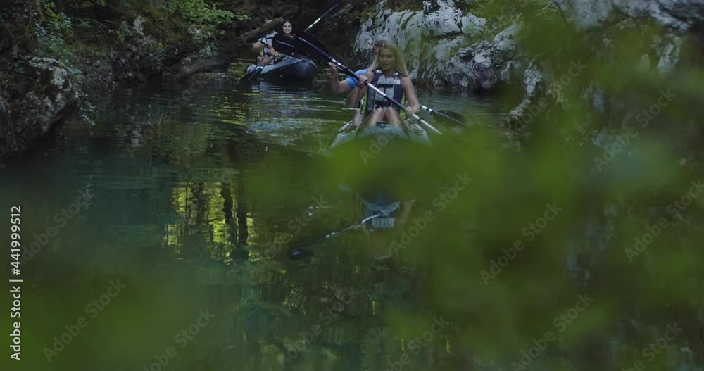 Kayak rowing slow motion. Kayaker woman and man kayaking in a beautiful landscape with friends. Kayakers couple practice sports in a kayak at the lake. Water sports during summer. Kayak rowing slow motion. Kayaker woman and man kayaking in a beautiful landscape with friends. Kayakers couple practice sports in a kayak at the lake. Water sports during summer.