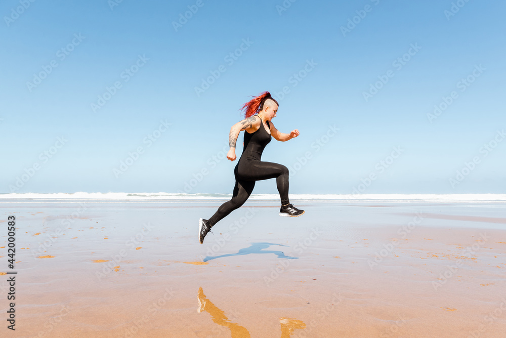 Fast runner jogging on sandy sea beach during workout Fast runner jogging on sandy sea beach during workout