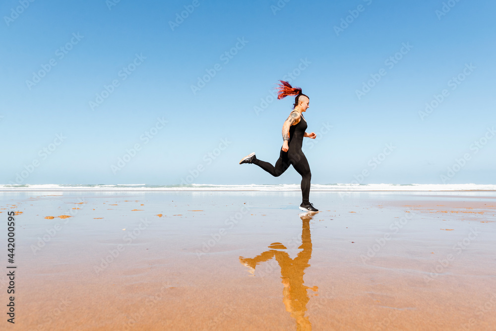 Fast runner jogging on sandy sea beach during workout Fast runner jogging on sandy sea beach during workout
