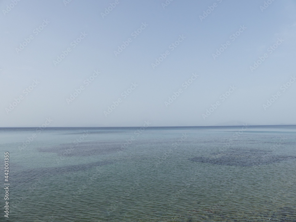 sea and sky with clear water on a foggy day in Corfu Greece