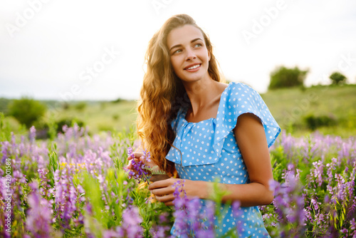 Portrait of beautiful woman in amazing in a blooming field. Nature, vacation, relax and lifestyle. Summer landscape.