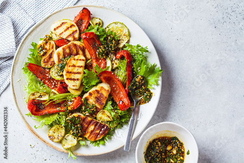 Grilled halloumi salad with baked vegetables and mustard dressing. Comfort food concept. photo