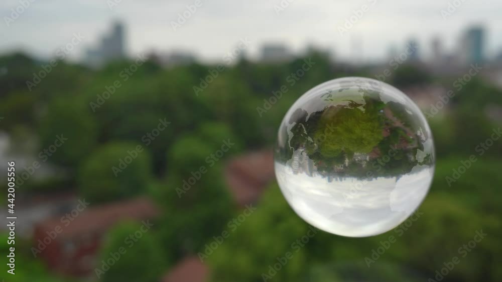 Floating glass Earth with city background.
World map etched onto a rotating glass sphere with an urban skyline background.