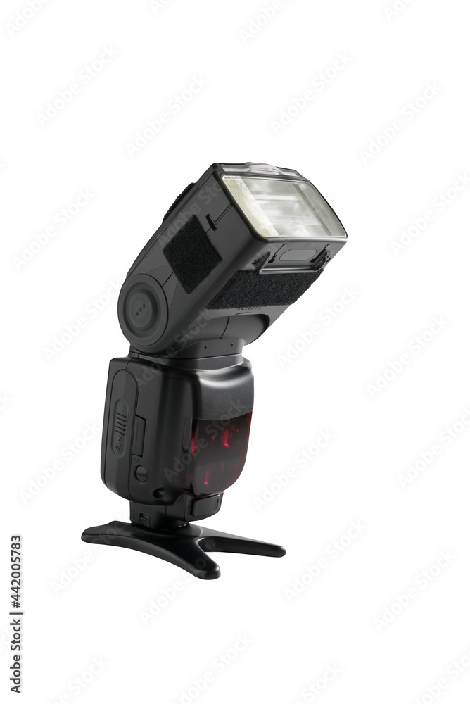 A professional, expensive external remote photography digital travel flash standing on a table tripod, cut out on white background with copyspace A professional, expensive external remote photography digital travel flash standing on a table tripod, cut out on white background with copyspace