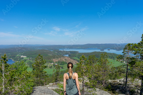 Girl wearing green top looking out over the landscape of the High Coast, Vasternorrland, Sweden photo