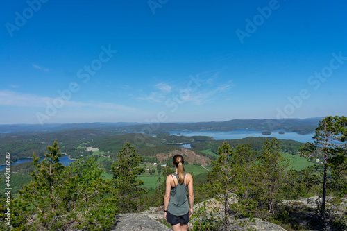 Girl wearing green top looking out over the landscape of the High Coast, Vasternorrland, Sweden photo