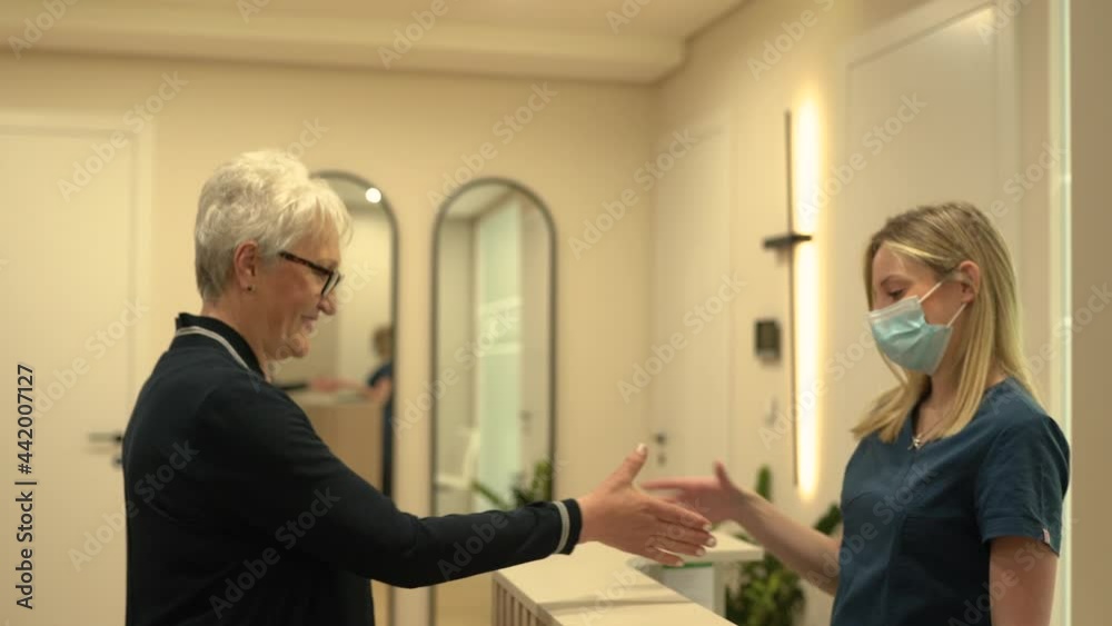 Dentist greeting senior patient at reception area. Dentist greeting senior patient at reception area.
