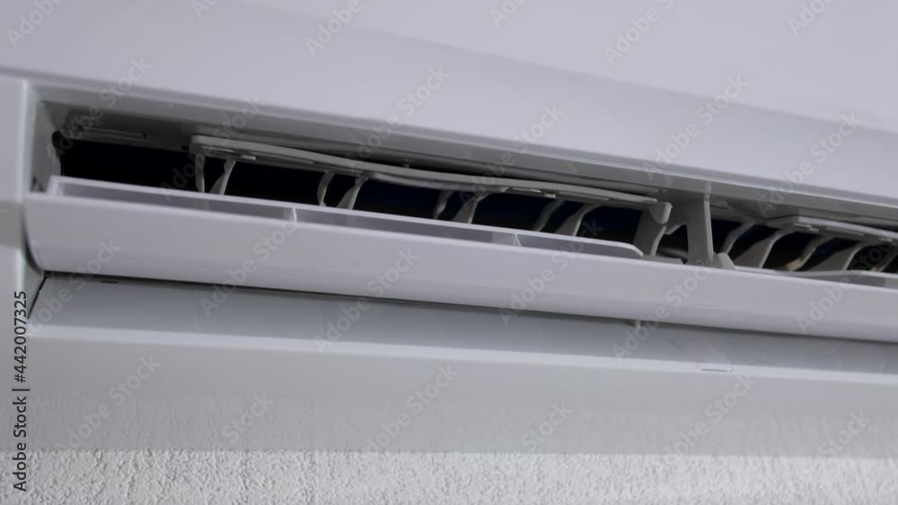 Start and end work of air conditioner. The activation of air conditioner, close up view. The cooling device is working on the room wall. Start and end work of air conditioner. The activation of air conditioner, close up view. The cooling device is working on the room wall.