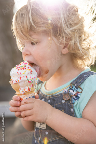 Little girl enjoying an ice cream cone with sprinkles