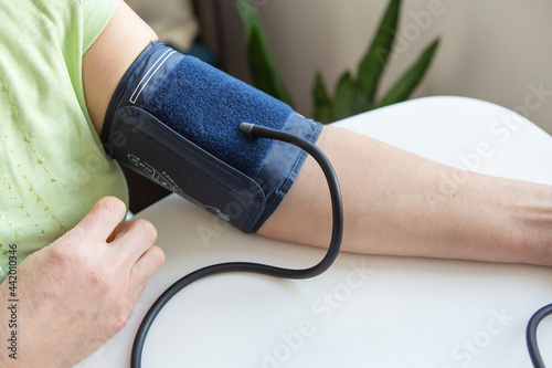 Measurement of blood pressure. A device for measuring blood pressure on a woman's hand.