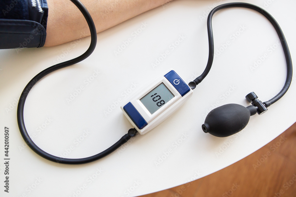 Health and care concept. Measurement of blood pressure. The woman measures blood pressure. Self-diagnosis at home. View from above. Health and care concept. Measurement of blood pressure. The woman measures blood pressure. Self-diagnosis at home. View from above.