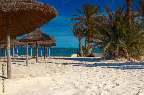 Fototapeta Naklejka Na Ścianę i Meble -  View of the white sand beach and parasols on the Mediterranean coast with birch water.