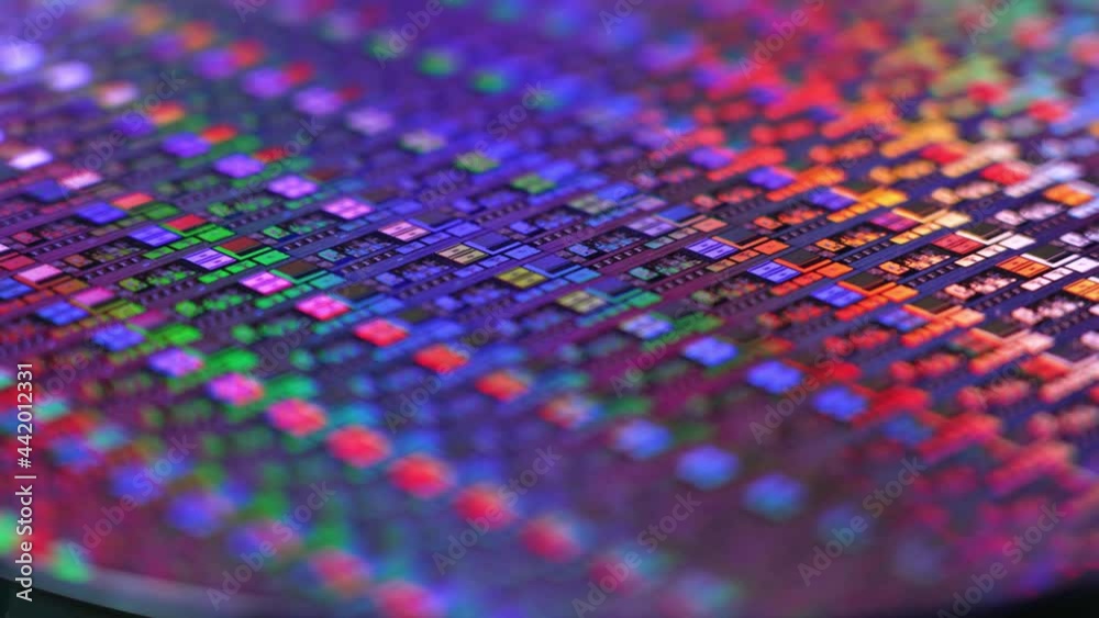 A slowly rotating colorful silicon wafer. Microchips suffered a shortage after the Coronavirus pandemic of 2020.  	