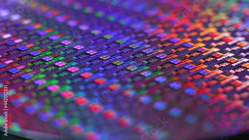 A slowly rotating colorful silicon wafer. Microchips suffered a shortage after the Coronavirus pandemic of 2020.  	 photo