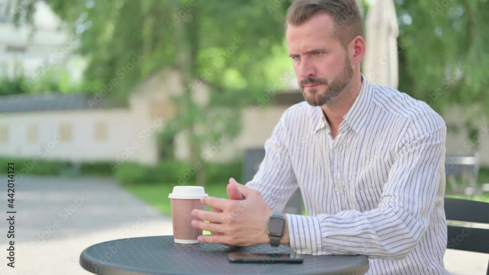 Middle Aged Man Feeling Angry while Waiting in Outdoor Cafe Middle Aged Man Feeling Angry while Waiting in Outdoor Cafe