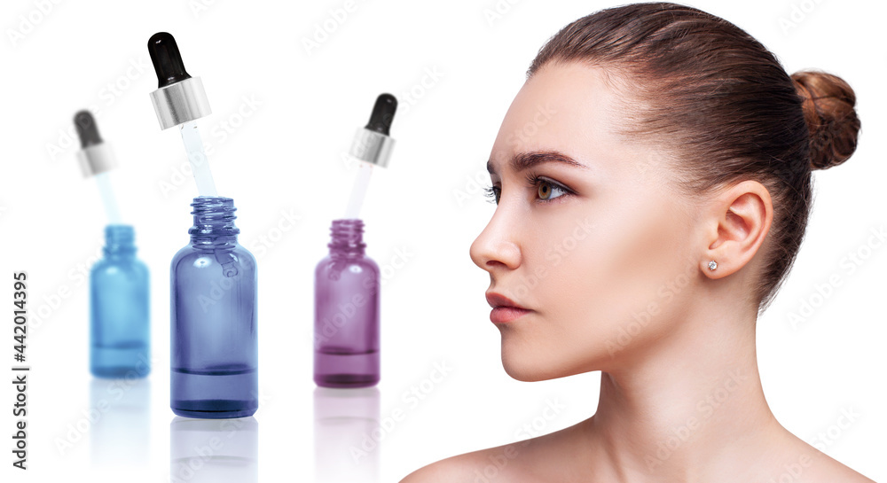 Cosmetics oil in bottle near beautiful face of young woman. Cosmetics oil in bottle near beautiful face of young woman.