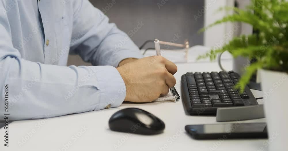 Man at desk fills out paperwork. Doctor writes appointment of treatment. Office manager during work. Man at desk fills out paperwork. Doctor writes appointment of treatment. Office manager during work.