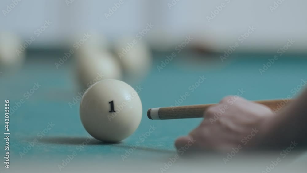 The billiard ball, number one, is hit with a cue