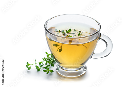 Green tea with lemon balm herb in glass cup isolated on white