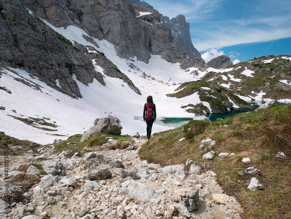 Woman with backpack hiking on top of a mountain. Beautiful landscape. Italian Alps, Dolomitit.