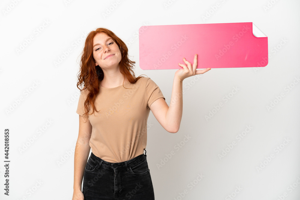 Teenager redhead girl isolated on white background holding an empty placard Teenager redhead girl isolated on white background holding an empty placard