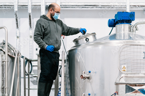 Brewer checking up lauter tun at work in beer factory photo