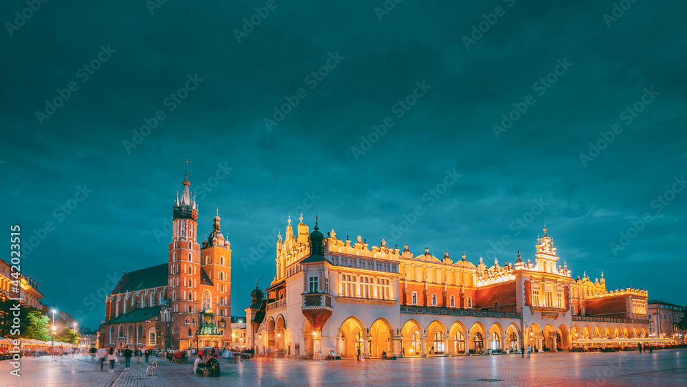 Krakow, Poland. Evening Night View Of St. Mary's Basilica And Cloth Hall Building. Famous Old Landmark Church Of Our Lady Assumed Into Heaven. UNESCO World Heritage Site