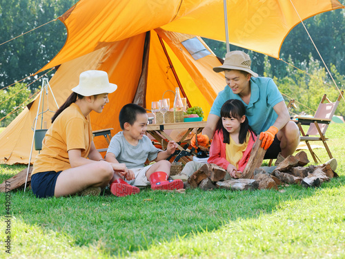 A Happy family of four camping outdoors