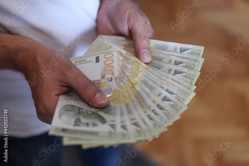 Male hands holding a pile of money. Serbian dinar paper currency, 2000 dinars value