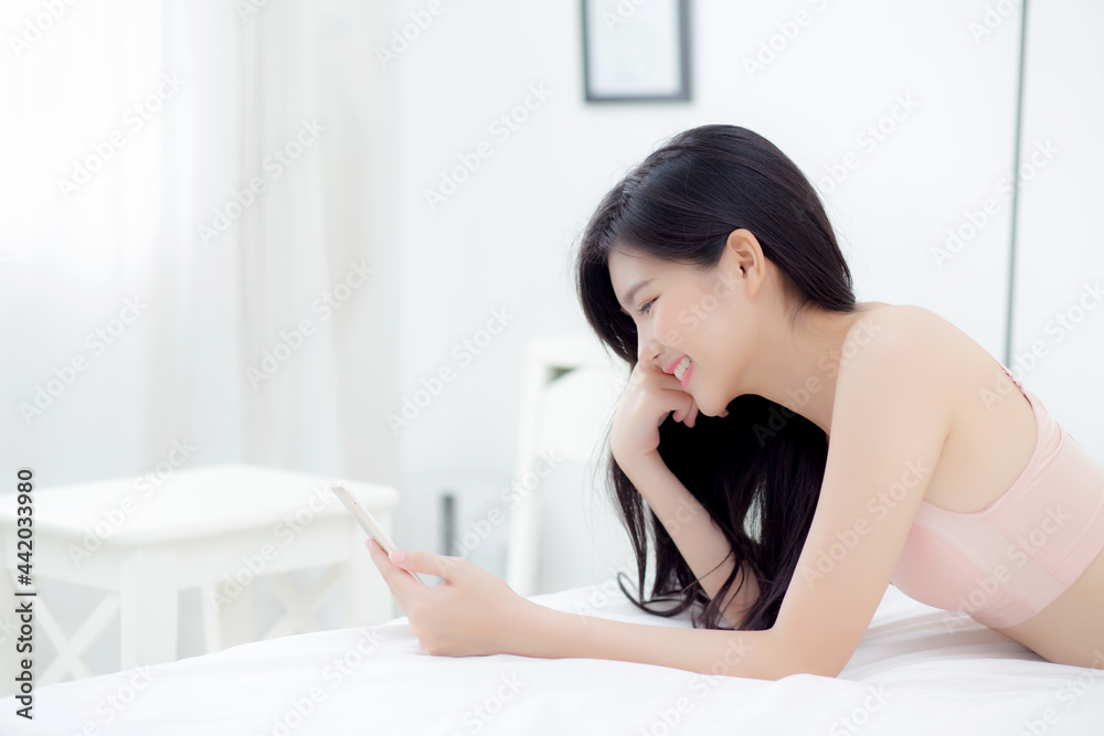 Beautiful young asian woman sexy in underwear chatting on mobile phone in the bedroom, happy girl in lingerie looking social media on smartphone lying on bed, communication and lifestyle concept. Beautiful young asian woman sexy in underwear chatting on mobile phone in the bedroom, happy girl in lingerie looking social media on smartphone lying on bed, communication and lifestyle concept.