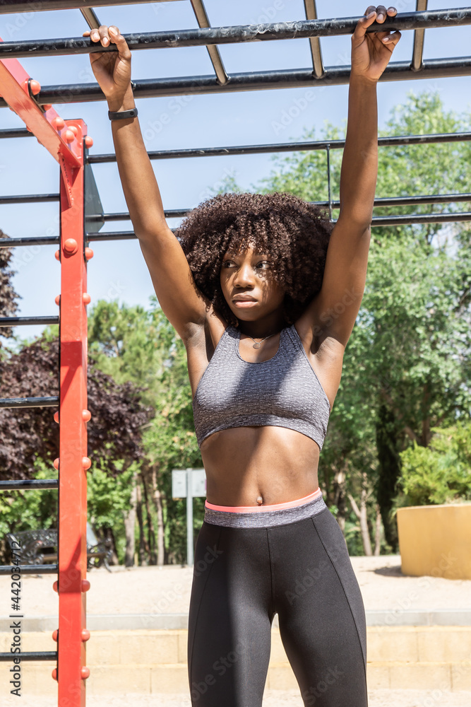 Obraz premium afro hair woman on calisthenics bars