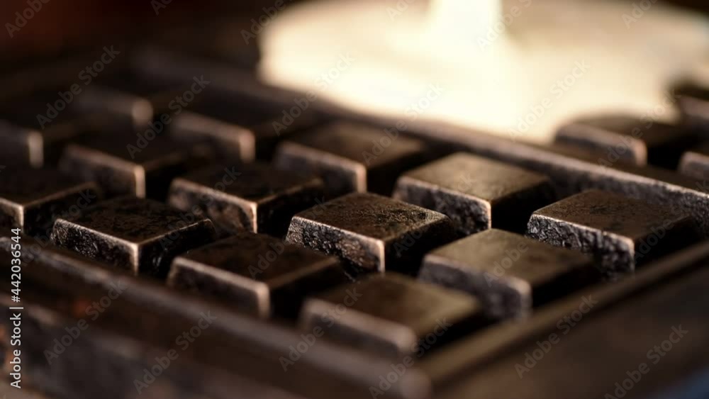 Closeup of raw pastry batter cooking in a waffle iron. The yeast dough bubbles and spreads across the hot plates of the waffle maker. The breakfast food is a family favorite for delicious brunch