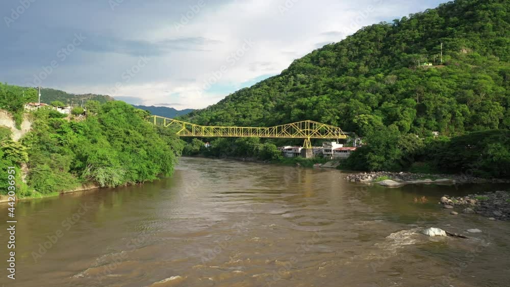 Aerial view of a bridge above muddy Magdalena river and green hills of colombian highlands near Honda town, Tolima, drone shot Aerial view of a bridge above muddy Magdalena river and green hills of colombian highlands near Honda town, Tolima, drone shot