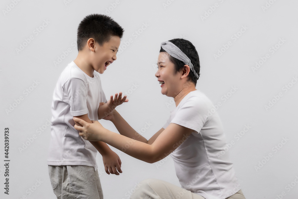 Young adult female cancer patient spending time with little son on gray background. Cancer and family support concept. Young adult female cancer patient spending time with little son on gray background. Cancer and family support concept.