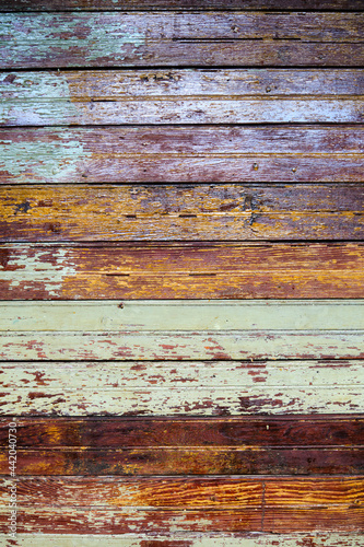 Texture, old rustic paint-striped wood slatted wall covered with peeling paint.
