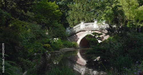 Static view of Parc Monceau with beautiful stone bride across river on summer day in Paris, France. photo