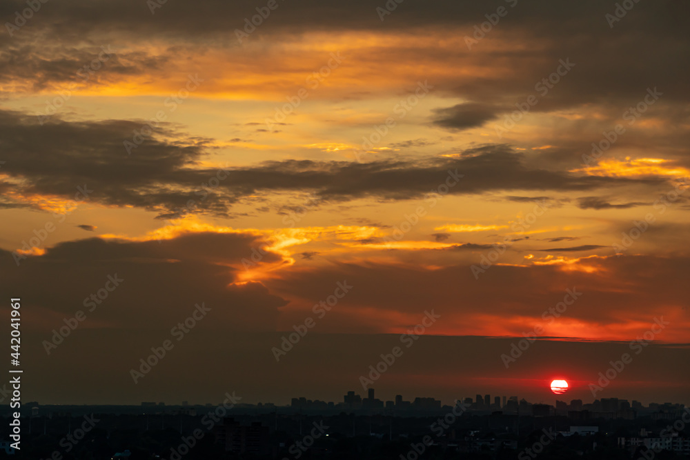 Sunset cityscape. Evening clouds and sun in the American city. Cloudscape summer nature. Clean of birds, bugs, and dust.