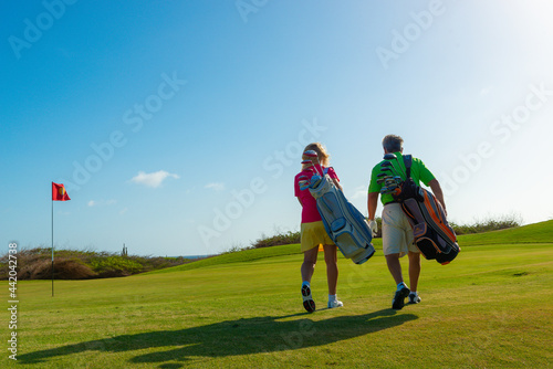 Active senior couple playing golf.