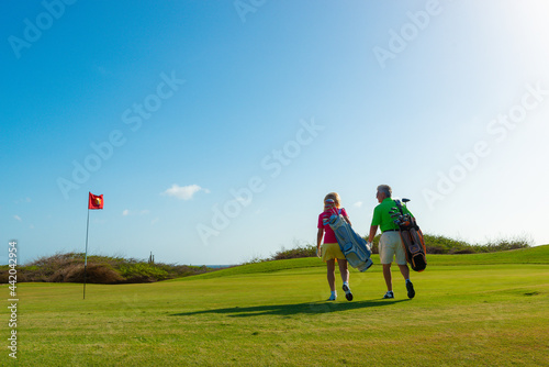 Active senior couple playing golf.