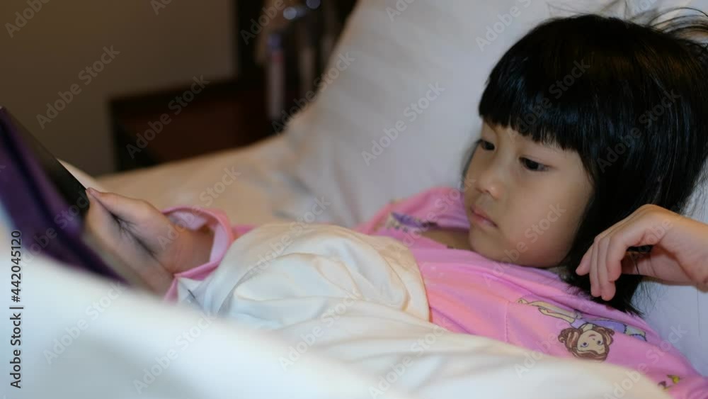 kid watching tablet on the bed at night time
kid watching tablet on the bed at night time