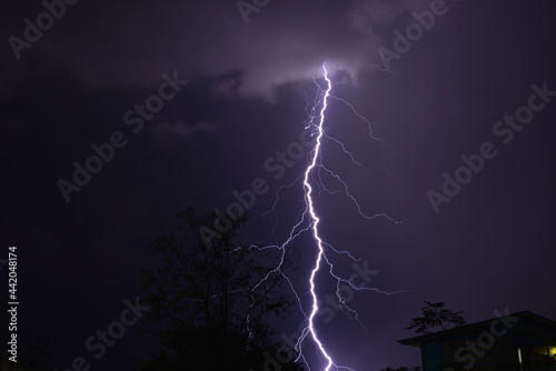 Lightning strike over homes during a summer thunderstorm