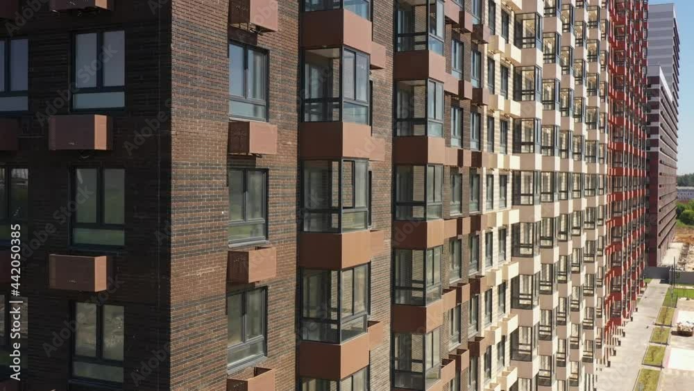 New modern designer brick apartment building in a modern residential complex in the summer. aerial view New modern designer brick apartment building in a modern residential complex in the summer. aerial view
