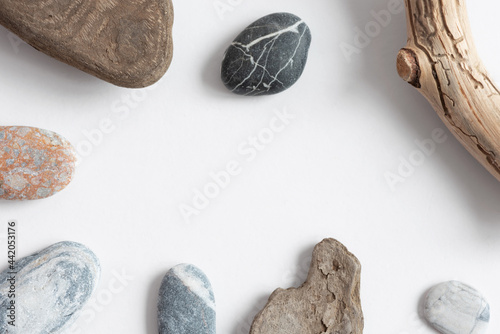 Natural frame with copy space from river pebbles, driftwood and driftwood. Top view, copy space.