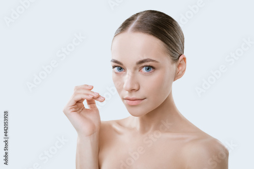 Portrait of a beautiful young woman of Caucasian ethnicity with clean skin on a white background. Natural cosmetics for facial skin care. Facial plastics concept