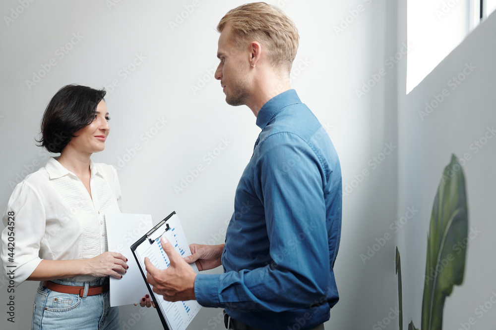 Smiling young businesswoman looking at coworker explaining his creative idea Smiling young businesswoman looking at coworker explaining his creative idea